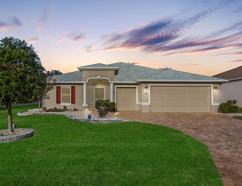 Open living room with sliding glass doors opening to a screened lanai with golf course views.