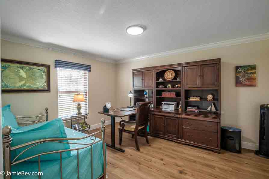 Open living room with sliding glass doors opening to a screened lanai with golf course views.