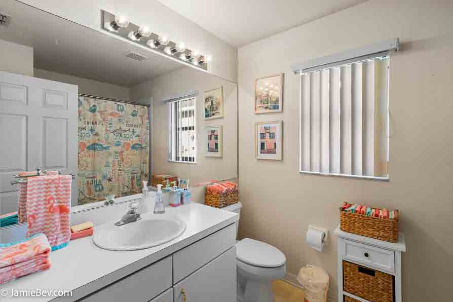 Bathroom vanity with storage, countertop space, and a decorative mirror.
