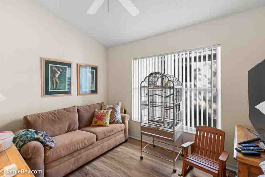 Spacious den with vinyl plank flooring and a large window.
