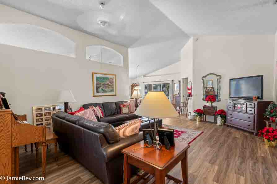Spacious great room with vinyl plank flooring and large windows.