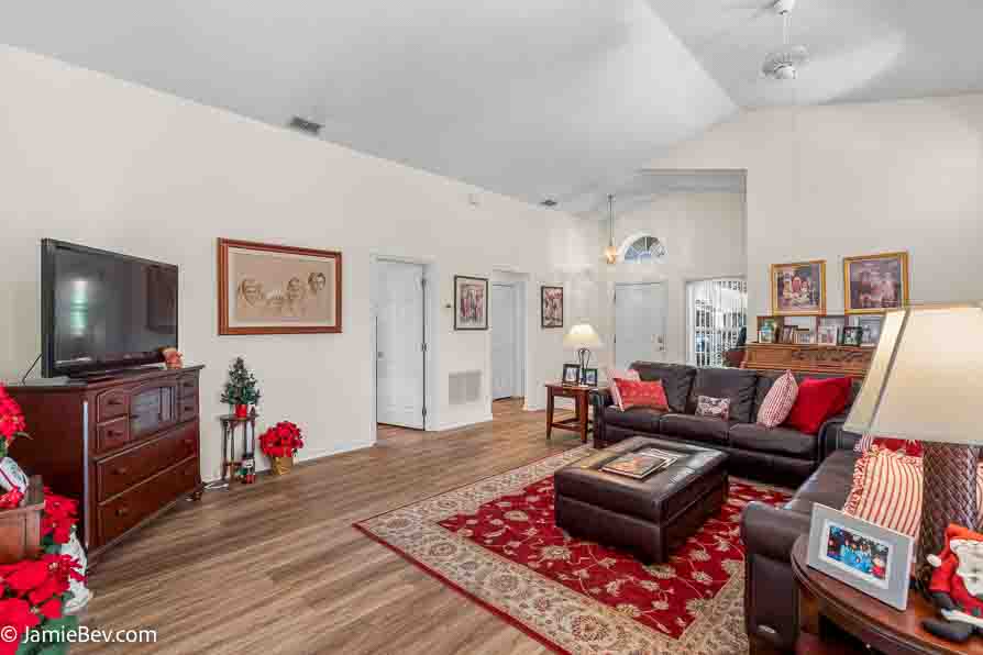 Spacious great room with vinyl plank flooring and large windows.