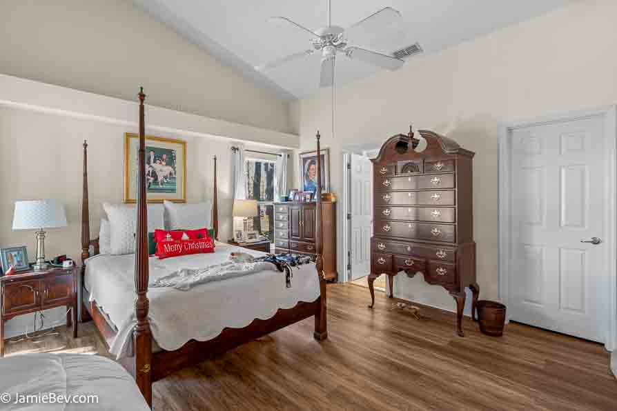 Primary bedroom with natural light and vinyl plank flooring.