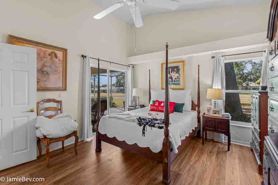 Primary bedroom with natural light and vinyl plank flooring.