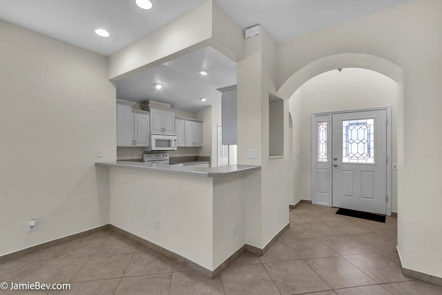 Bright open floor plan with large windows, allowing natural light to fill the living room with scenic golf course views.