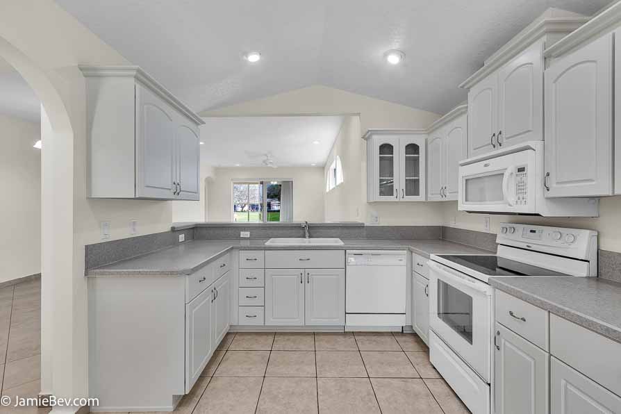 Kitchen with stainless steel appliances, a spacious countertop, and a cozy breakfast nook with bay windows.