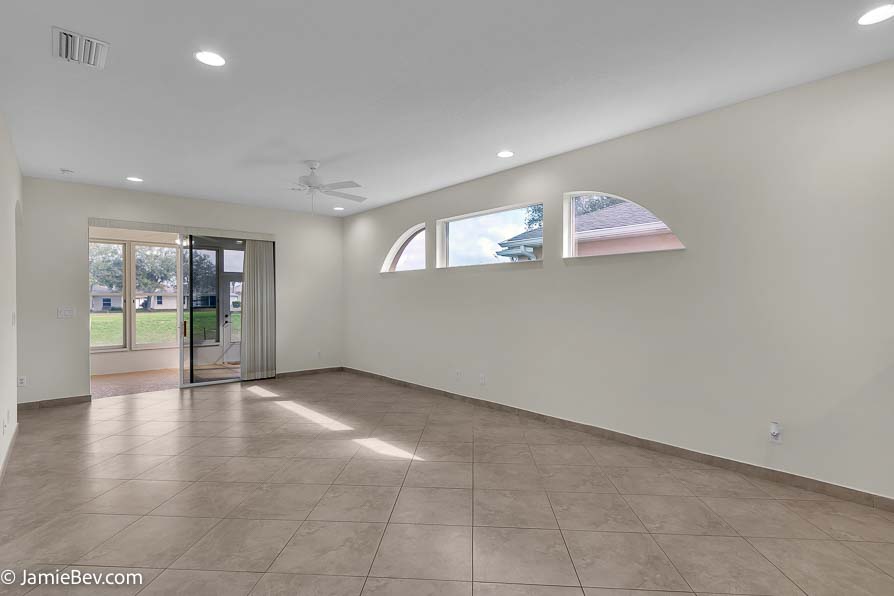 Bright open floor plan with large windows, allowing natural light to fill the living room with scenic golf course views.