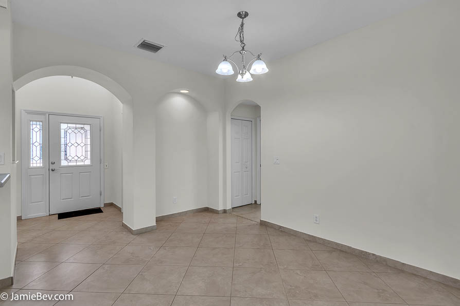Bright open floor plan with large windows, allowing natural light to fill the living room with scenic golf course views.