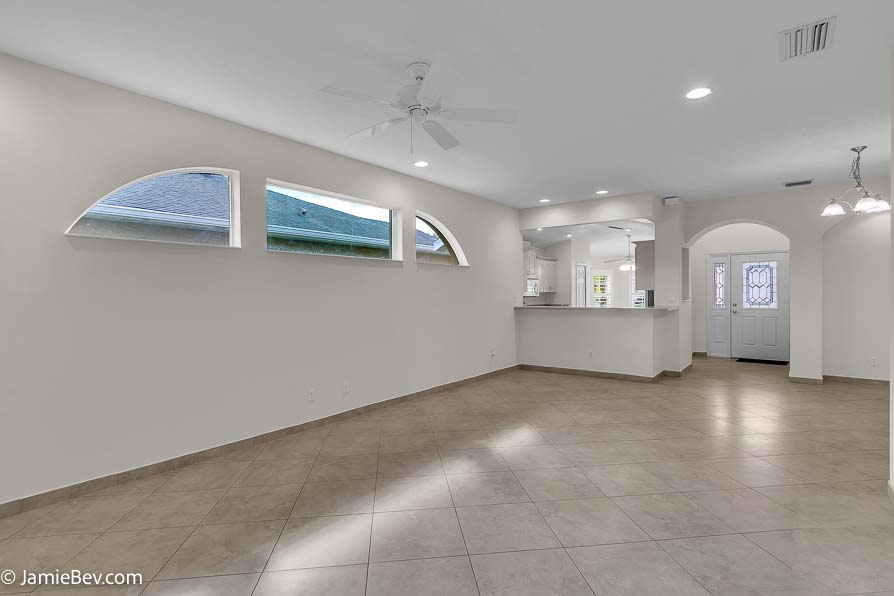 Bright open floor plan with large windows, allowing natural light to fill the living room with scenic golf course views.