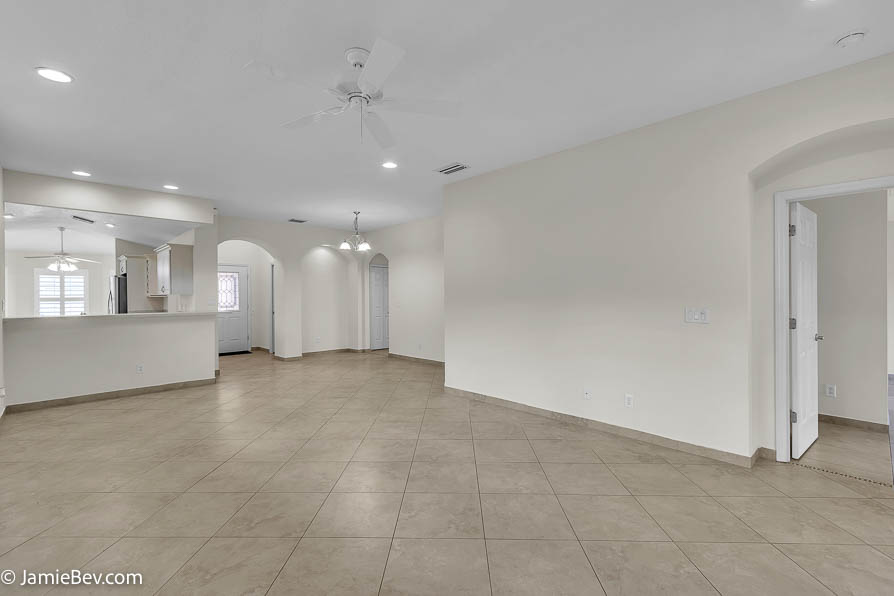 Bright open floor plan with large windows, allowing natural light to fill the living room with scenic golf course views.