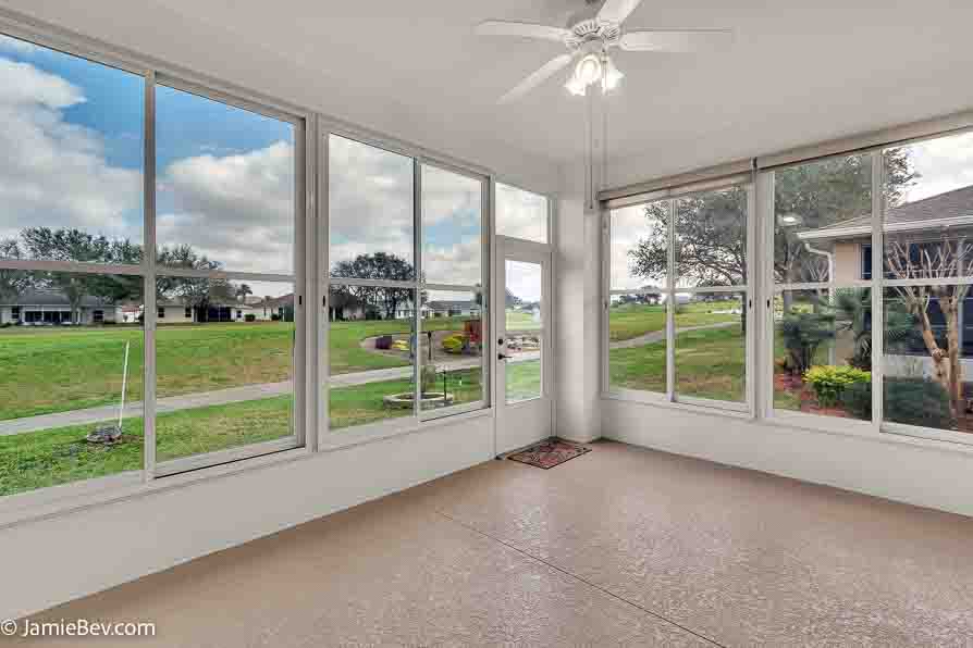 The Florida Room at 4835 Kelso St., offering breathtaking views of the golf course and perfect for relaxation.