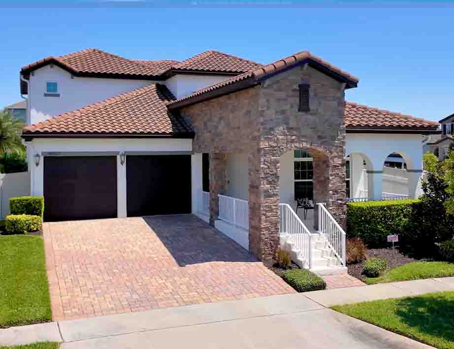 Front exterior of Spanish-style pool home on oversized double corner lot in Watermark, Winter Garden