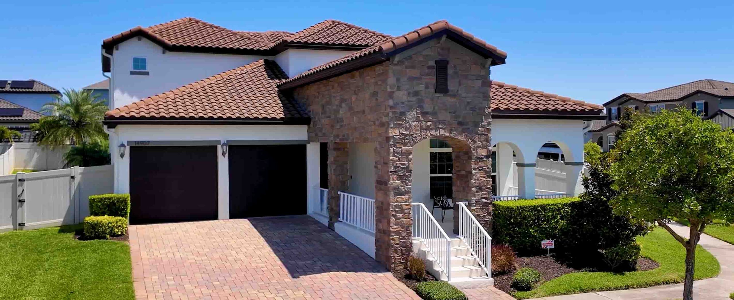 Front exterior of Spanish-style pool home on oversized double corner lot in Watermark, Winter Garden