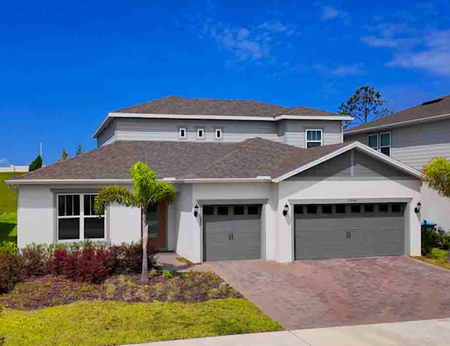 Ashby Grand home with paver driveway, three-car garage, and covered front porch entry.