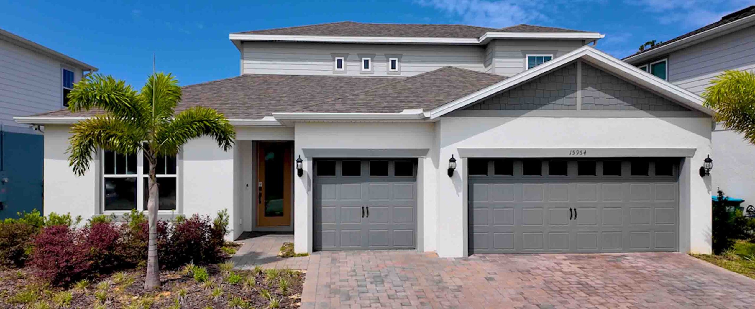 Ashby Grand home with paver driveway, three-car garage, and covered front porch entry.