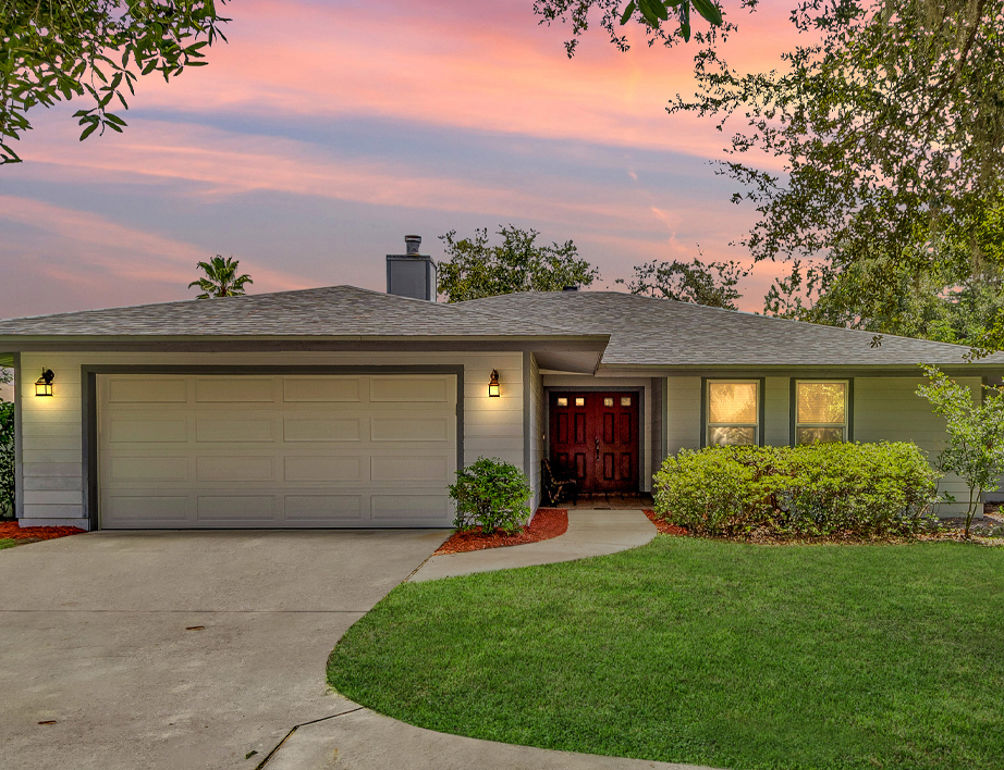 Front entry of Oviedo pool home with mature trees and private driveway.