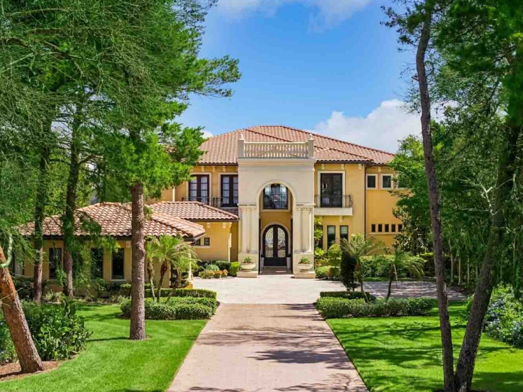 Colonnaded entry cloister with reflecting pool and terracotta roofline at Villa Esperanza, Montverde FL