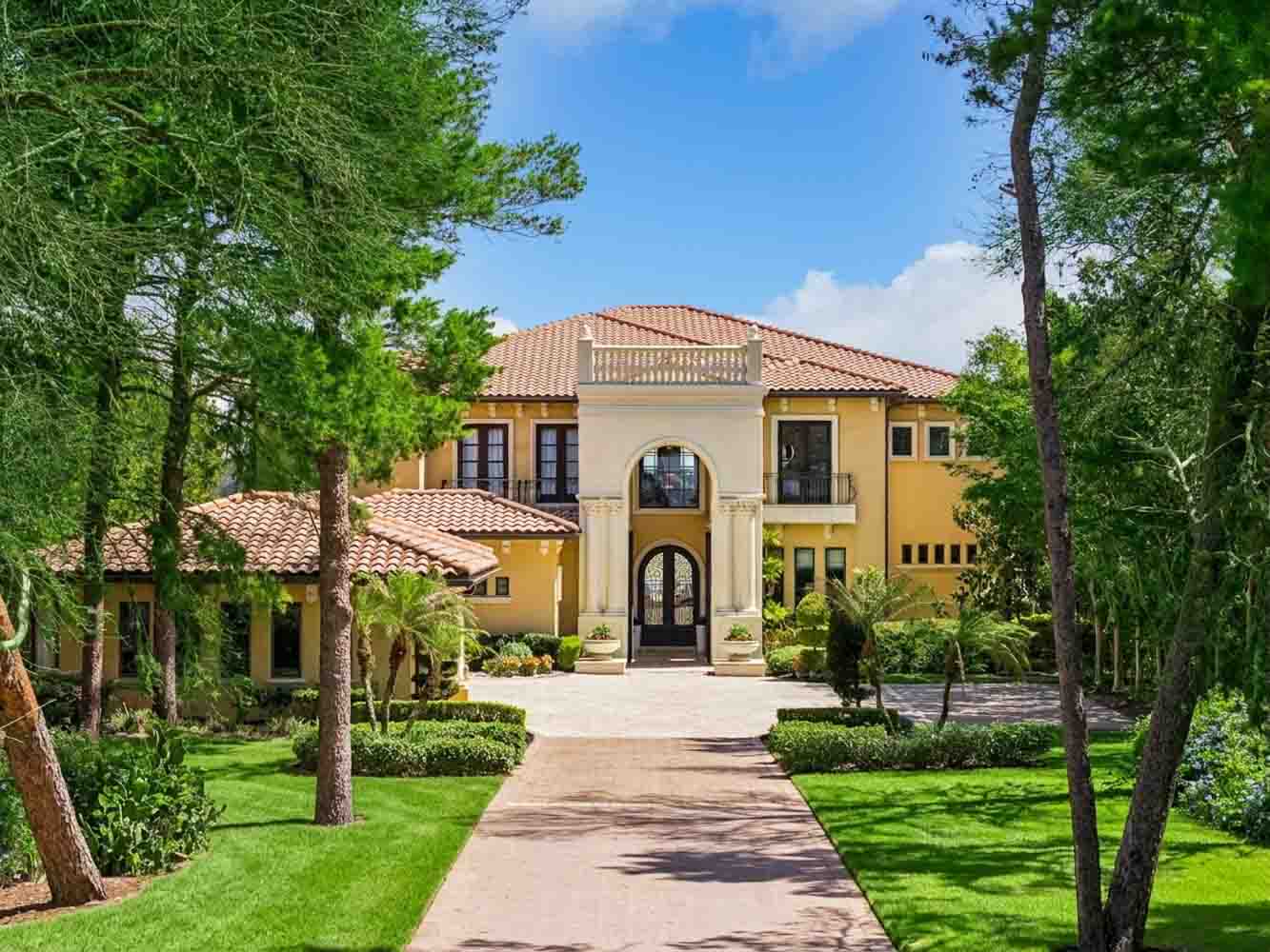 Colonnaded entry cloister with reflecting pool and terracotta roofline at Villa Esperanza, Montverde FL